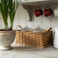 Kitchen counter with a woven basket, glass jars, and a potted plant.