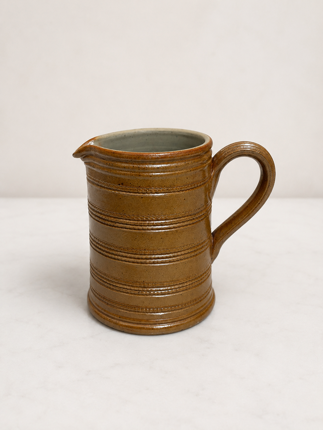 Brown ceramic pitcher on a white background