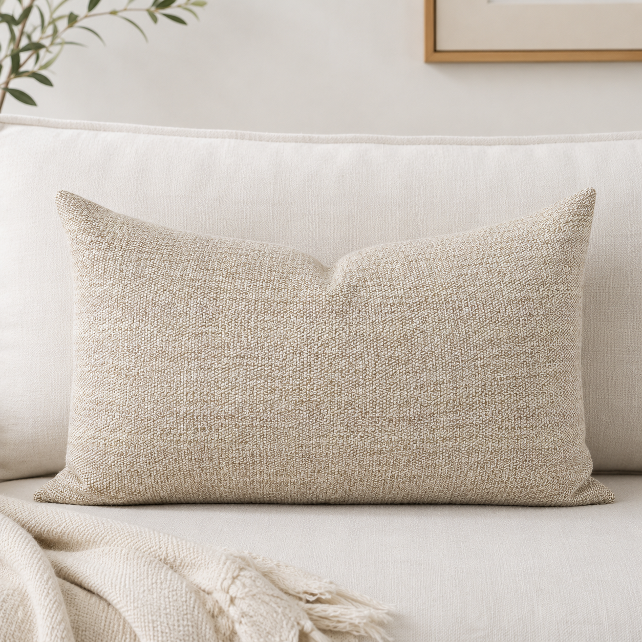 Textured beige pillow on a light-colored sofa with a neutral background