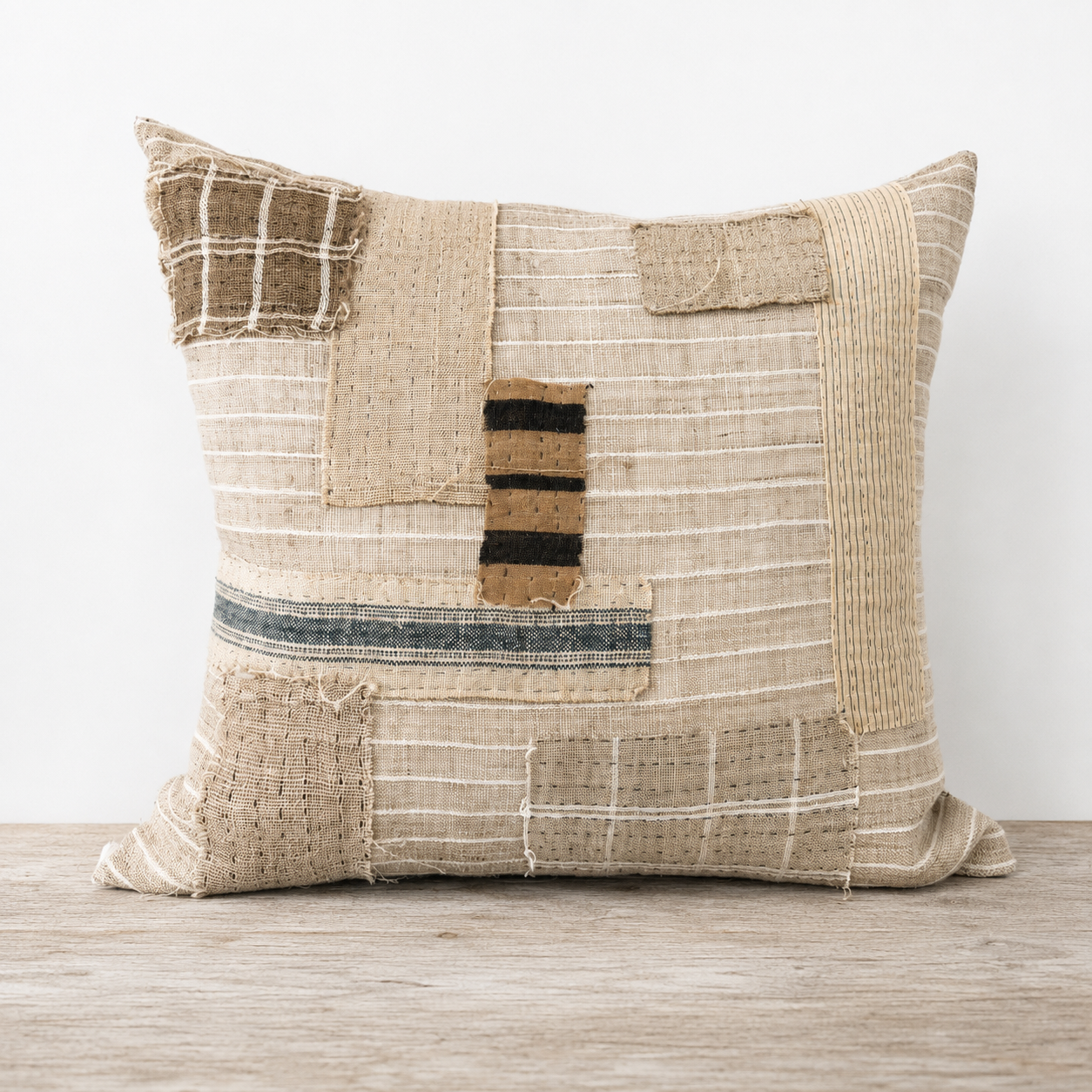 Textured pillow with patchwork design on a wooden surface