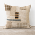 Textured pillow with patchwork design on a wooden surface